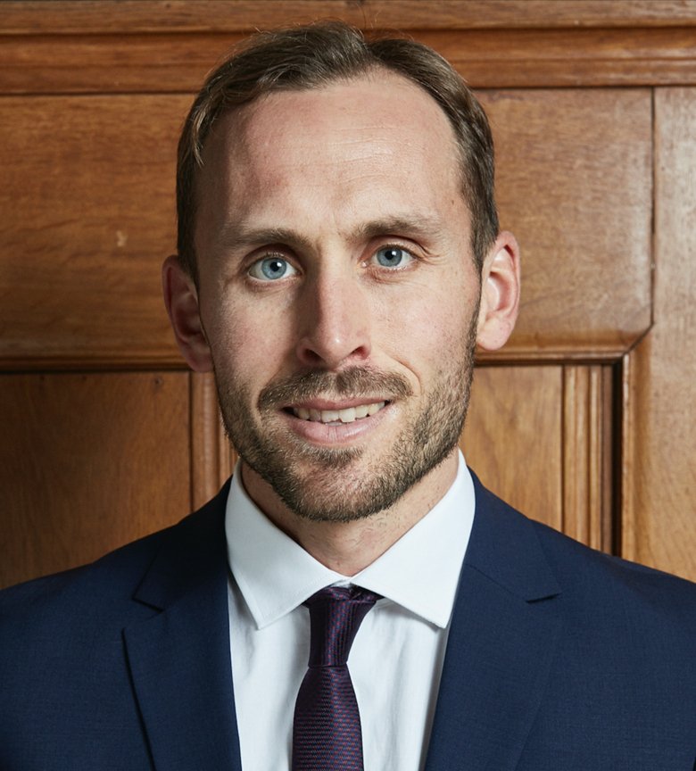 Portrait of Nils dressed in white shirt, jacket and a tie.