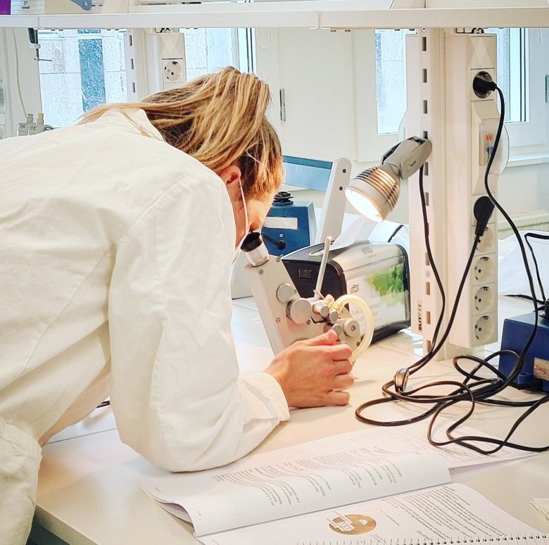 lab. miljö, student som tittar i ett mikroskop