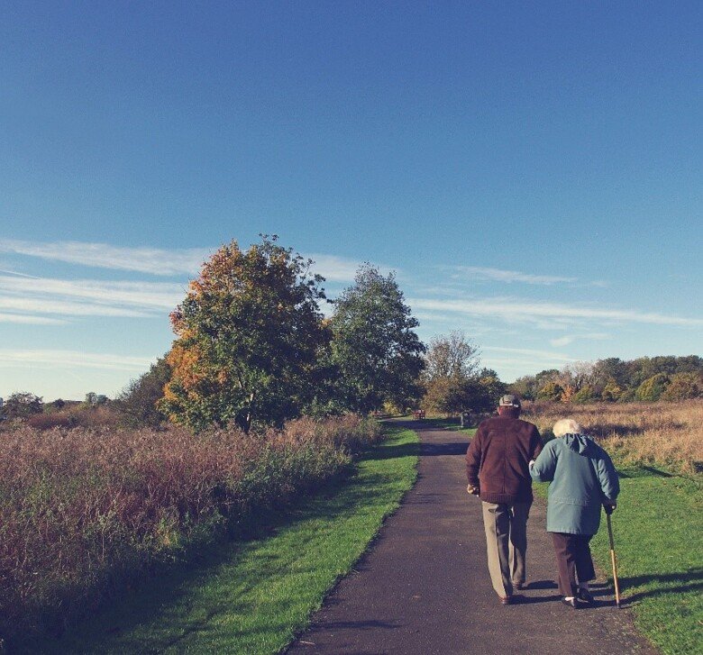 An elderly couple takes a walk.