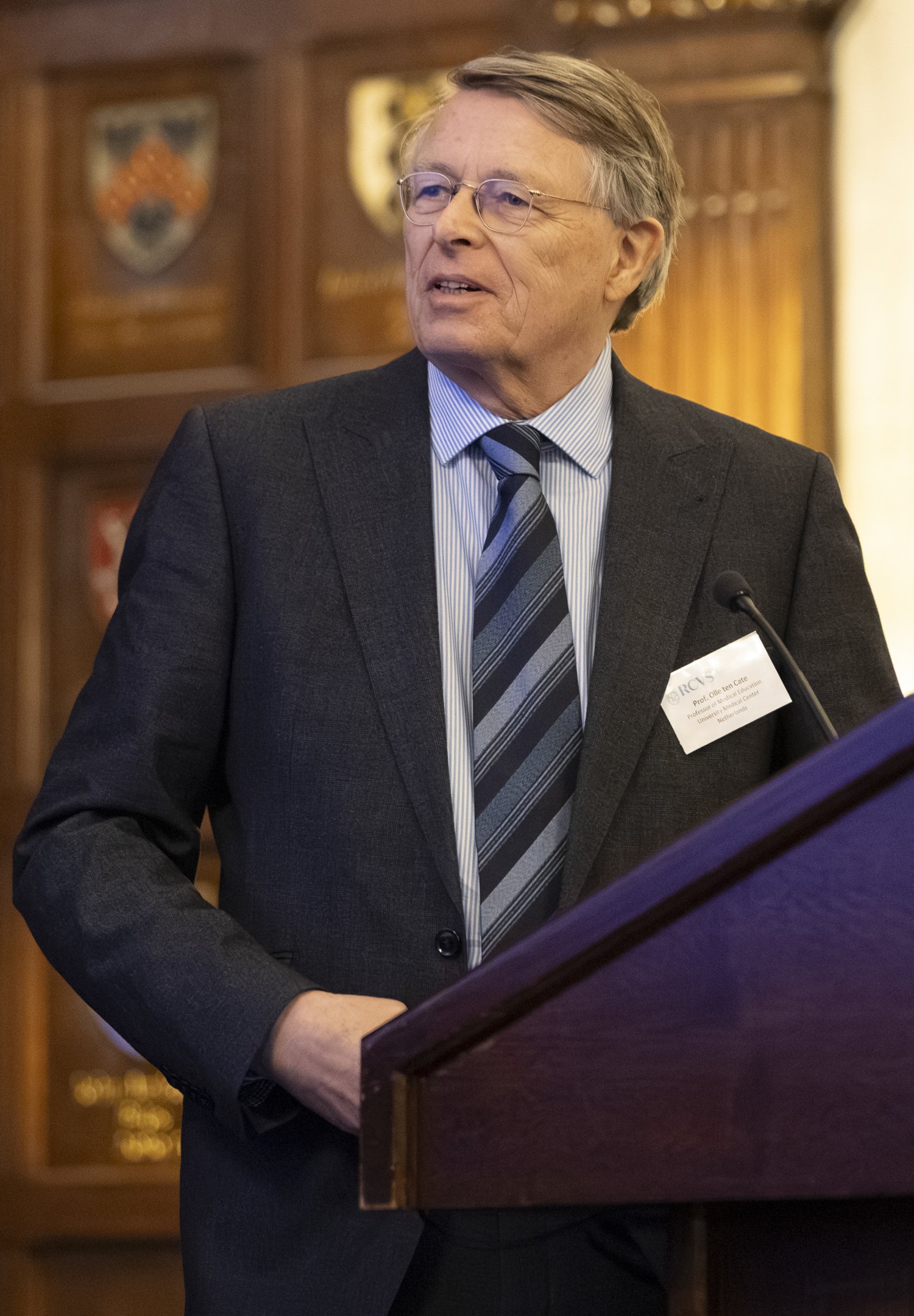 Olle ten Cate by a podium giving a lecture.