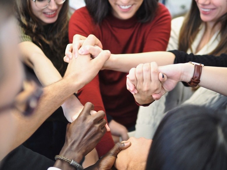 people joining hands in the middle