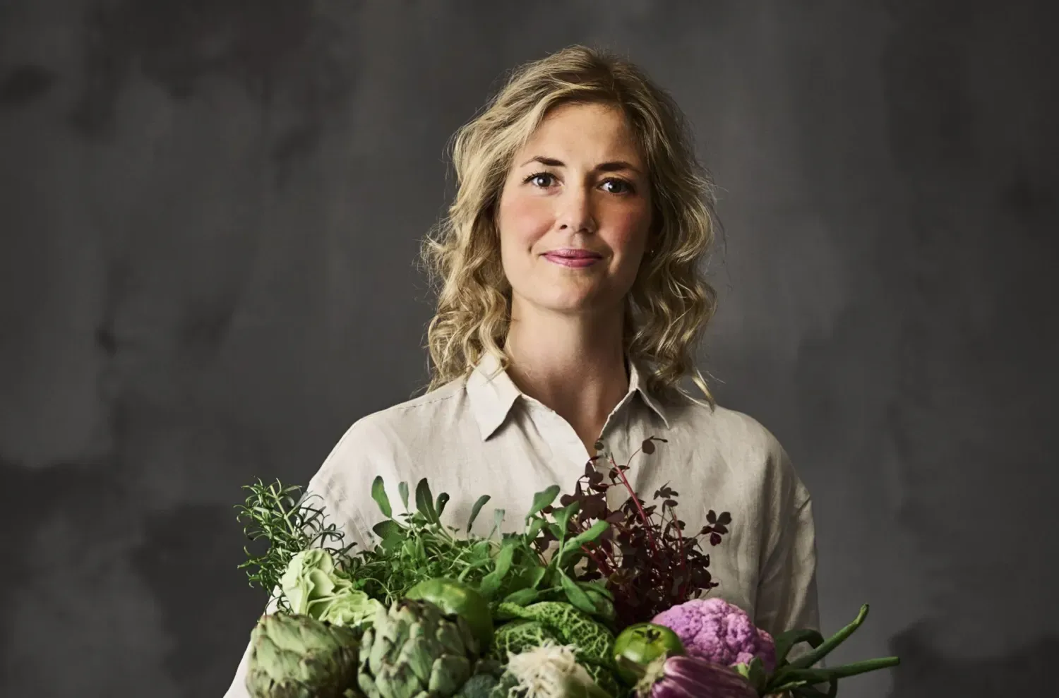 Porträtt av kvinna med blommor i händerna.