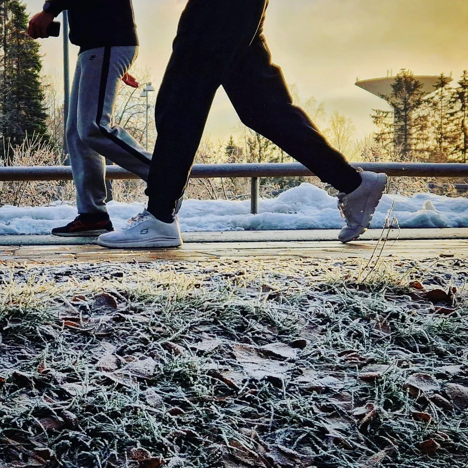 Two pair of legs walking. Water tower in the background.