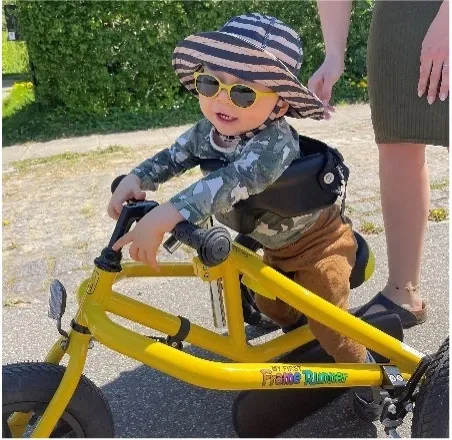 baby with sunglasses on a yellow bike