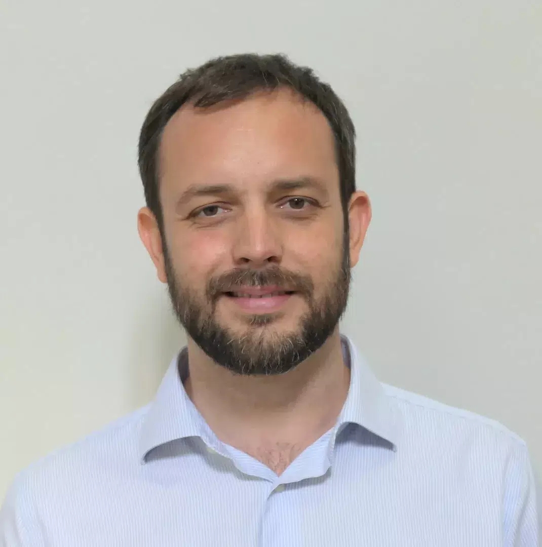 Portrait picture of Davide in light blue shirt against a light background.