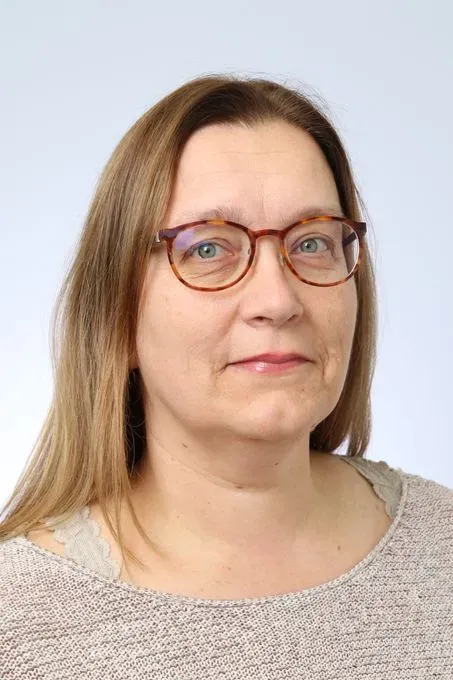 Porträtt av kvinna i ljus tröja.