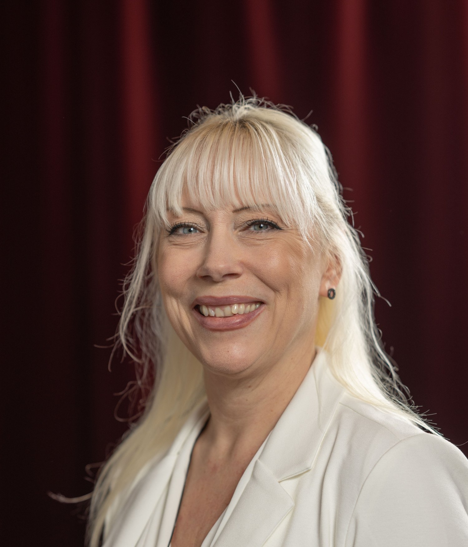 Porträttbild på leende, blond kvinna.