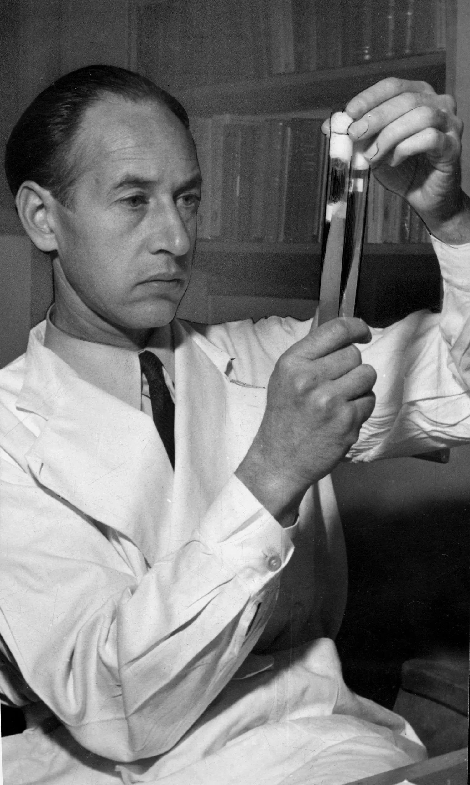 En forskare håller upp två provrör och granskar innehållet.