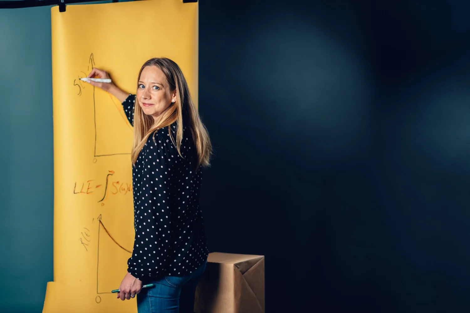 Therese Andersson ritar på gult papper.