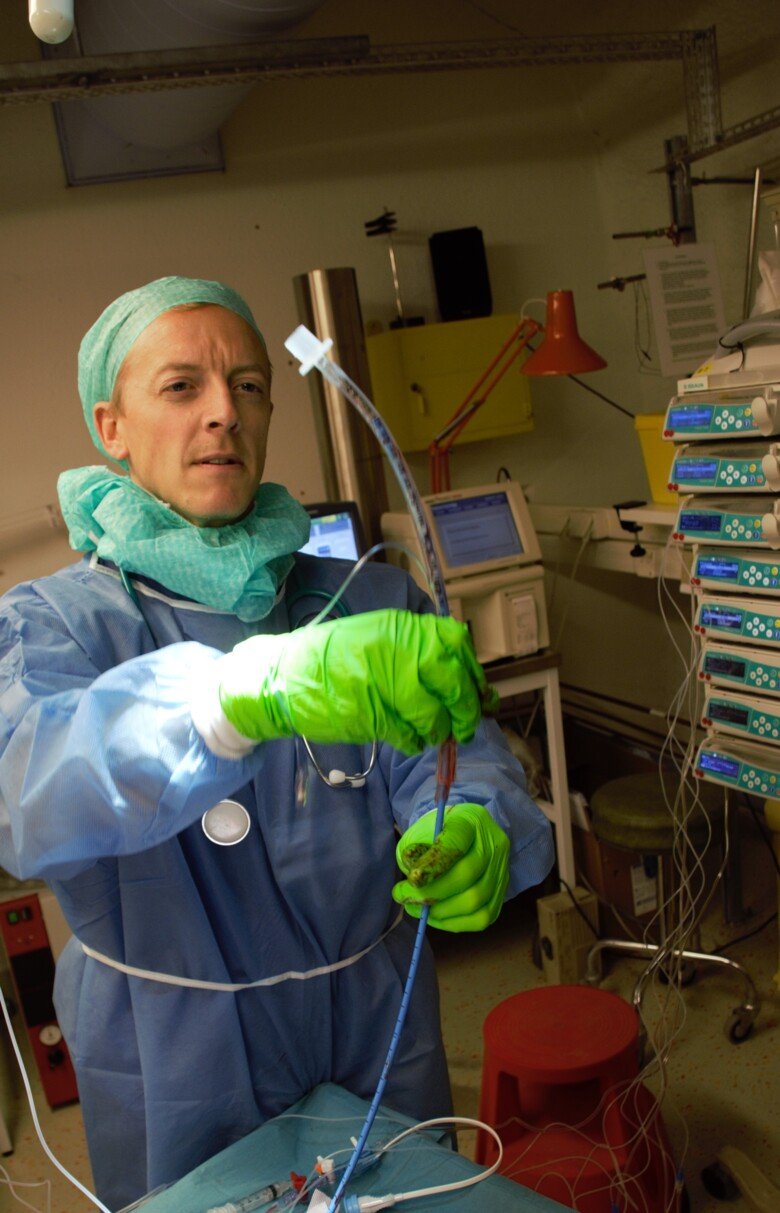 Lung and airway research performed by Tomas Karlsson in protective gear, holding a tube in front of him.