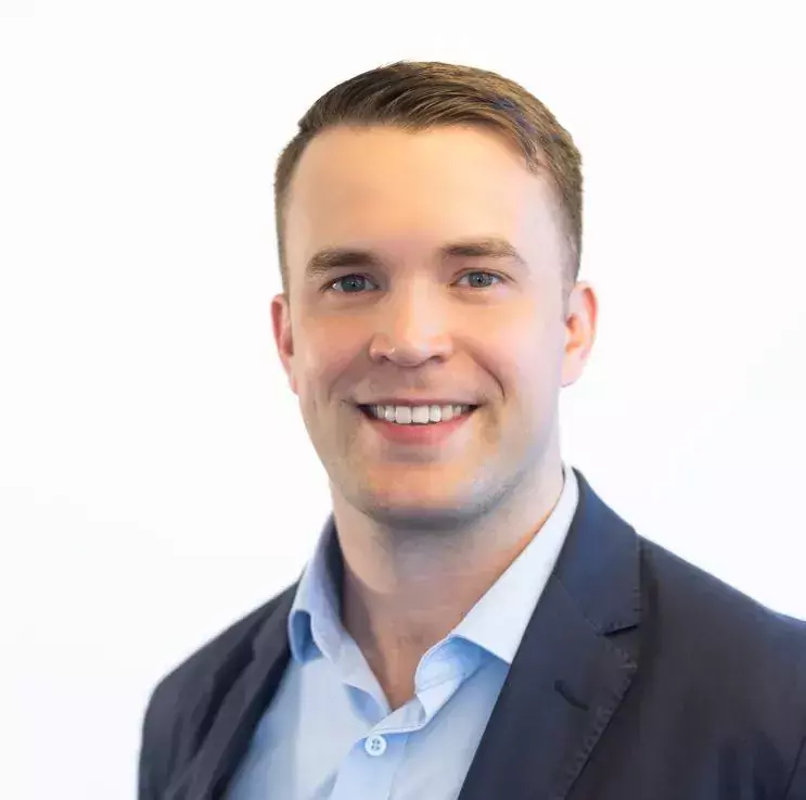 Alumn William Jonsson, smiling with a dark blazer and light blue shirt