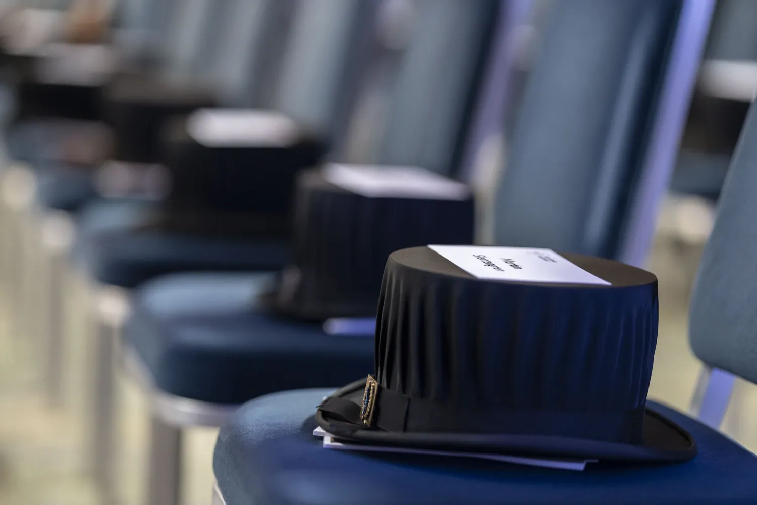 Doctor's hats and name tags on chairs standing in a row.