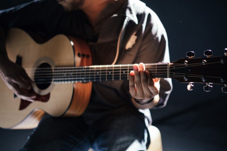 A man playing an aucustic guitarr