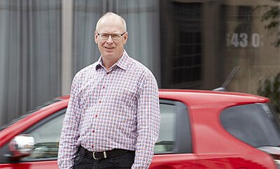 Researcher Anders Kullgren in front of a red car.