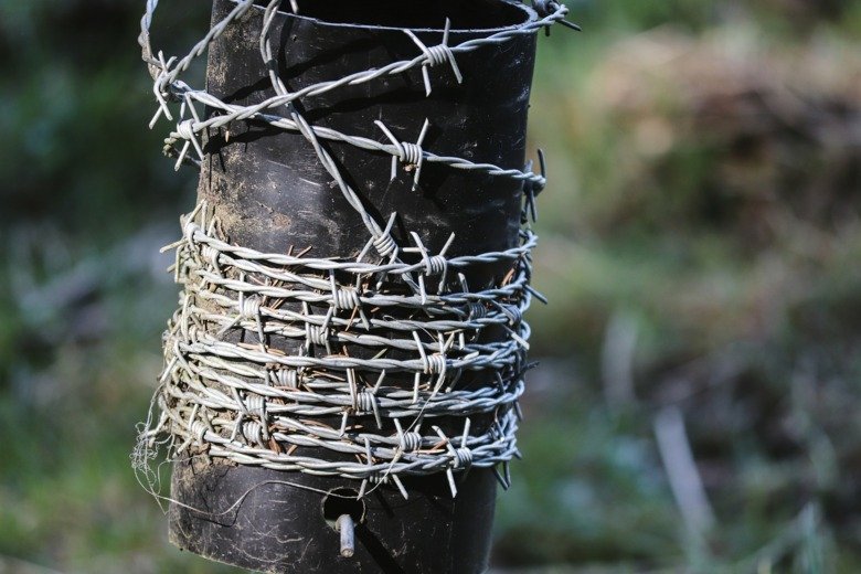 Barbed wire around a pillar.