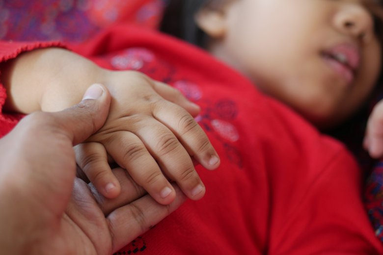 A child holding an adults hand