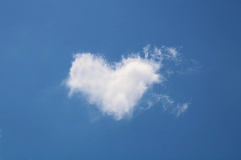 Heart shaped cloud in blue sky.