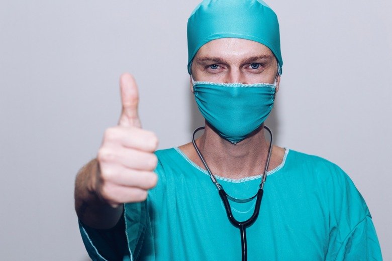 Doctor with face mask give thumbs up.