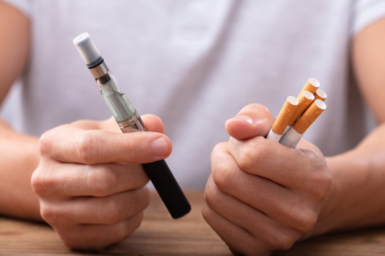 Man holds e-cigarettes in his hand.