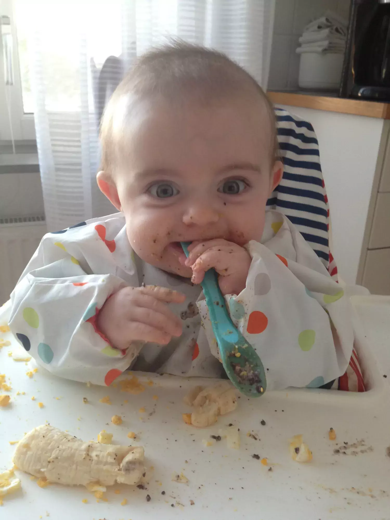 Child eating oat meal himself.