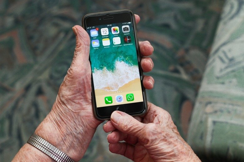 äldre persons händer med en smartphon mobiltelefon