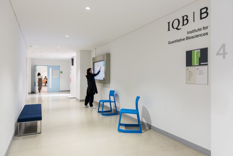 white corridor, women pointing on a screen.