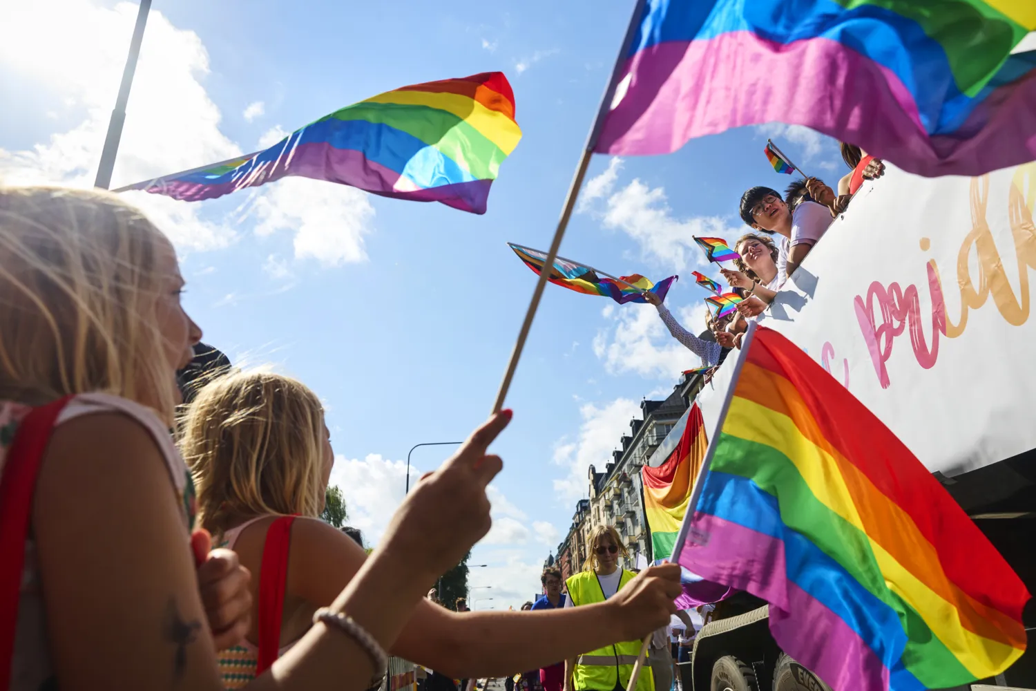 Students and other participants in the Pride parade. Rainbow flags and happy people.