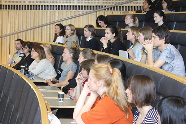 Students sit on their benches in the lecture hall and listen to a presentation