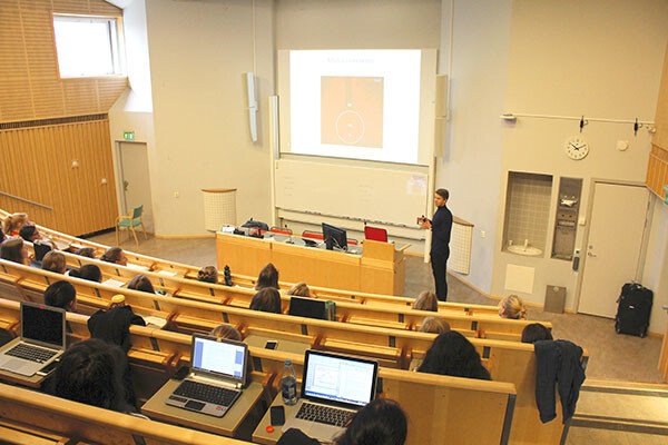 Lecture hall where teacher is presenting on a big screen