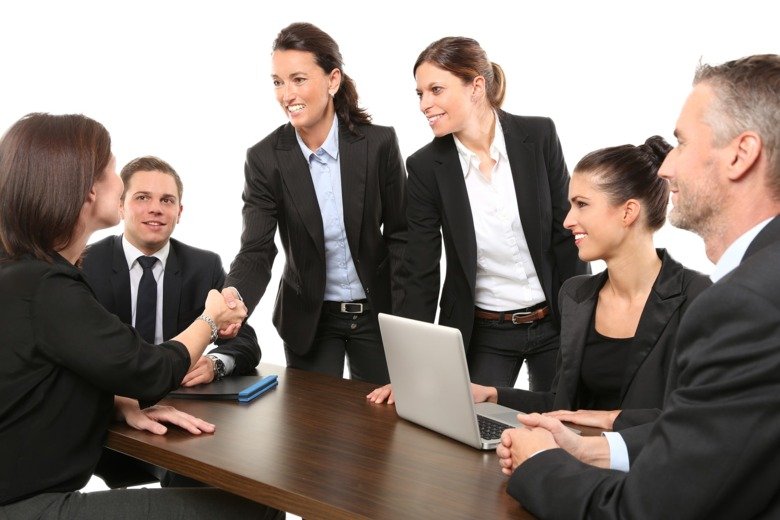 Boardroom meeting, men and women in suits.