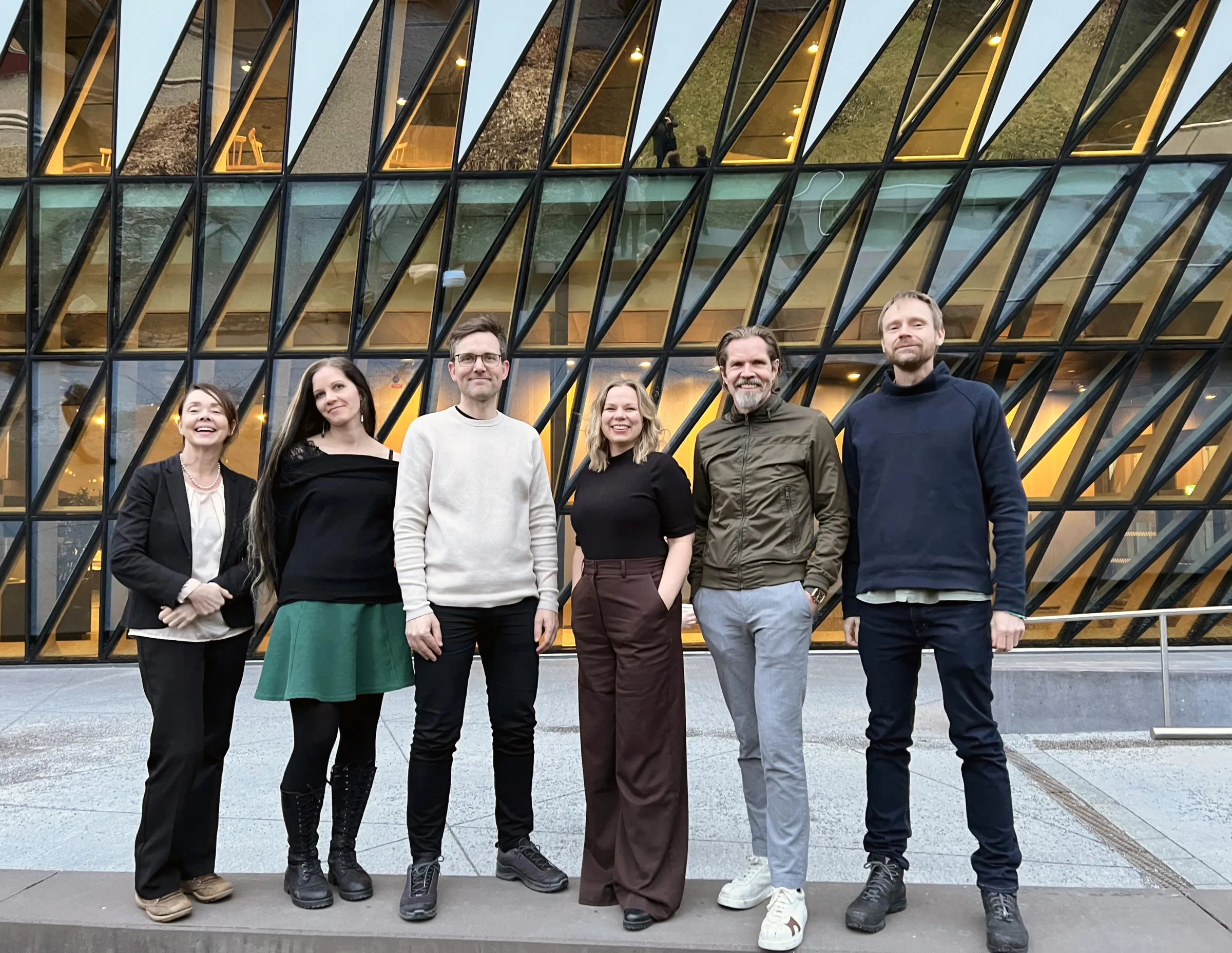 Three men and three women standing outside