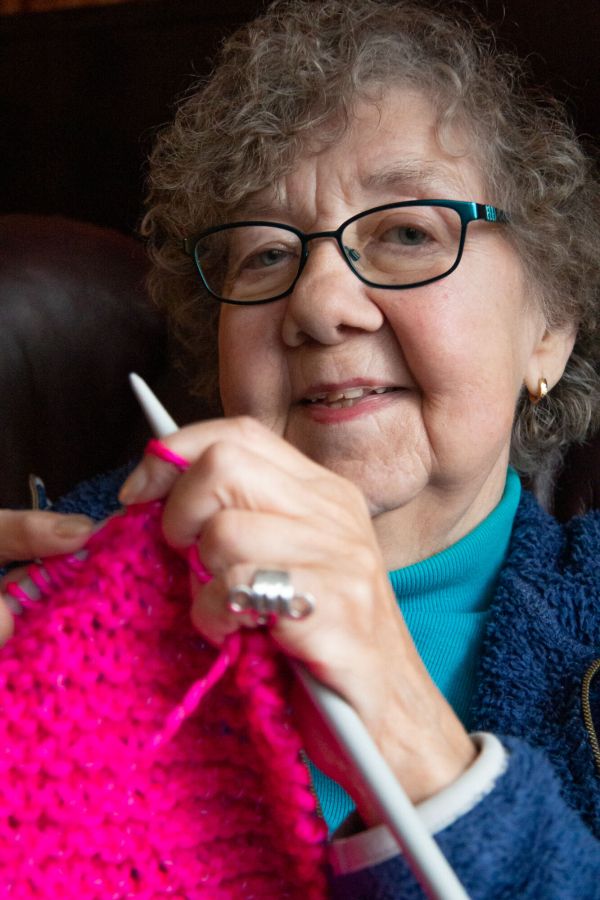 Vivianne, 76, knitting and smiling.