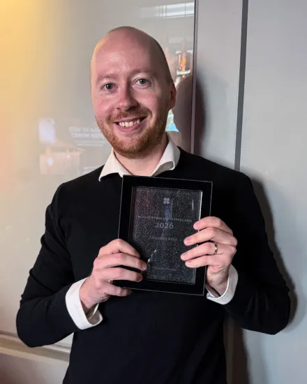 Alexander Kvist, postdoc vid avdelningen för fysioterapi, står med prisdiplomet (Elsa och Inge Anderssons pris 2026) i handen
