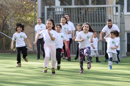 Children running over a football arena.