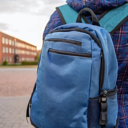 En ung person som står på en skolgård