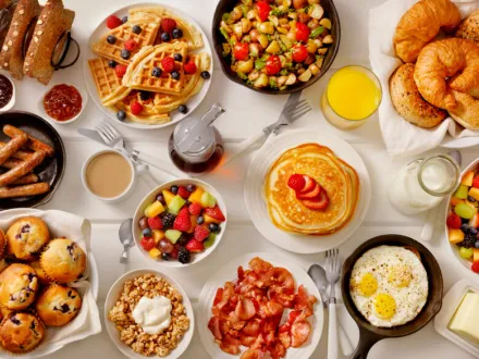Table with plates filled with breakfast meals.
