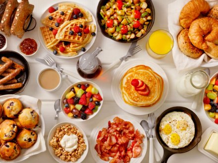 Table with plates filled with breakfast meals.