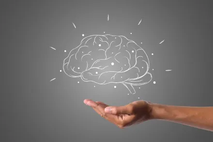 a brain hovers over a hand.