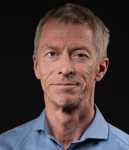 Porträtt av man i blå skjorta.