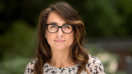 Portrait of a women with dark hair and glasses.