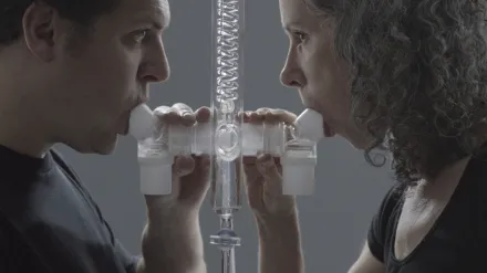 Image of two people blowing in nozzles.