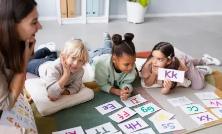 Barn och en lärare med bokstäver.