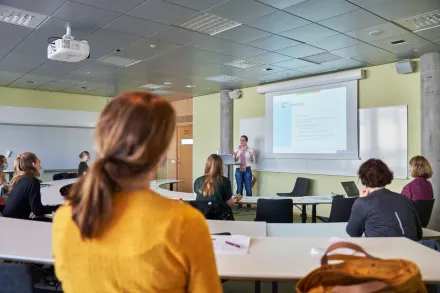 Lecture hall with students and professor lecturing.