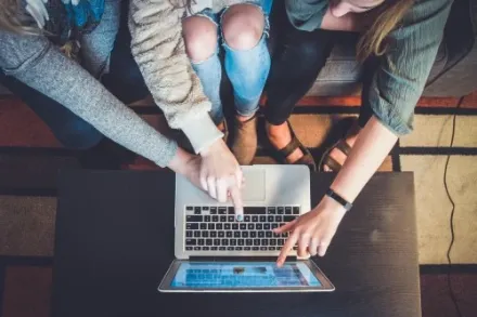 Students sitting next to computer