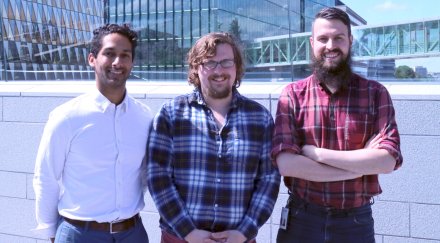 Photo of three researchers on bridge between Aula Medica and the new hospital building.