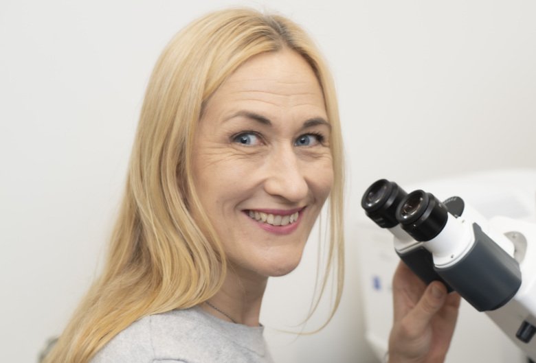 Camilla Svenson in front of a microscope.